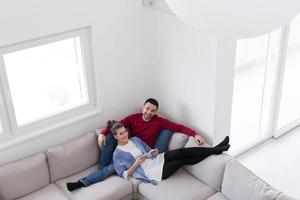 casal relaxando em casa com computadores tablet foto