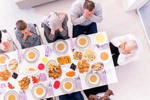 vista superior da família muçulmana moderna tendo um banquete do ramadã foto