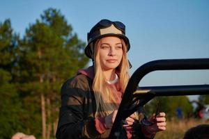 garota usando um capacete e curtindo um passeio de carro de buggy em uma montanha foto