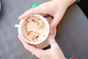 mãos de mulher com xícara de capuccino foto