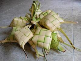 ketupat na indonésia é uma espécie de forma de cozinhar arroz inserindo arroz em uma folha de coco que tem a forma de um diamante. em seguida, cozido no vapor. muito famoso na indonésia. geralmente aparece no eid al-fitr foto