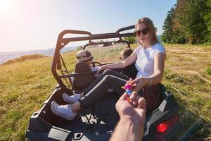 pessoas animadas se divertindo aproveitando um belo dia ensolarado segurando tochas coloridas enquanto dirigia um carro de buggy off road foto