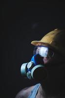 mineiro de retrato de perfil no capacete, respirador e óculos de proteção, olhando para o trabalhador light.dirty na camisa.
