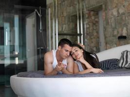 casal relaxa e se diverte na cama foto