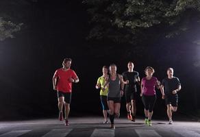 equipe de corredores no treinamento noturno foto