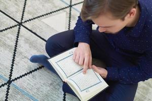 jovem muçulmano lendo o Alcorão durante o Ramadã foto