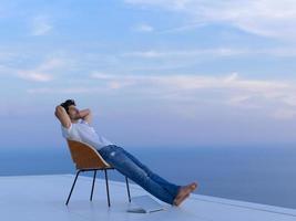 jovem relaxado em casa na varanda foto