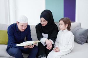 família muçulmana lendo o Alcorão e orando em casa foto