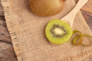 uma fatia de kiwi colocada na colher de madeira foto