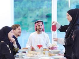 família muçulmana jantando iftar bebendo água para quebrar a festa foto