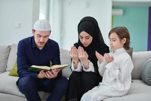 jovem família muçulmana lendo o Alcorão durante o Ramadã foto