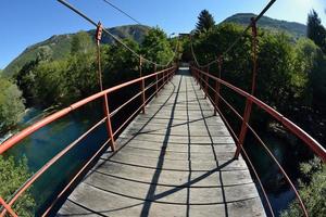 ponte de madeira sobre o rio selvagem foto