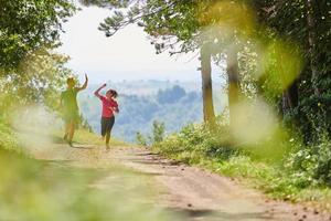 casal desfrutando de um estilo de vida saudável enquanto corre em uma estrada rural foto