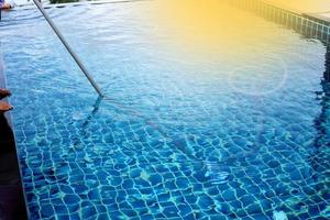 mulher trabalhadora piscina privada limpa com aspirador de tubo azul todas as semanas no verão, piscina tipo sal junto com o oceano como estilo horizontal com coqueiros foto