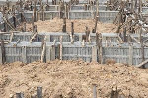 cofragem de blocos para vigas de casas apoiadas em toras de madeira. construção da fundação da casa no terreno durante o dia. foto