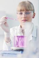 pesquisador feminino segurando um tubo de ensaio em laboratório foto