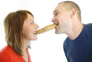 casal feliz comendo croissant foto