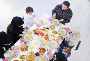 família muçulmana tradicional rezando antes do jantar iftar foto