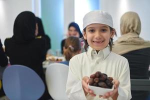 garoto árabe com roupas tradicionais durante iftar foto