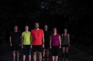 equipe de corredores no treinamento noturno foto