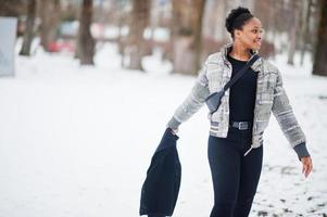 mulher africana usa em pose de cachecol preto em dia de inverno na europa. foto