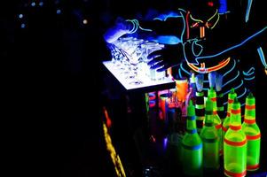 barman profissional e show de luzes led. silhueta do barman moderno, agitando a bebida no bar de coquetéis à noite. foto