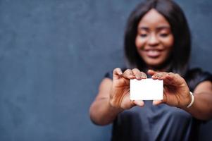 mulher africana segura cartão vazio nas mãos. foto