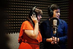 jovens cantores de dueto asiáticos com música de gravação de microfone no estúdio de música de gravação. foto