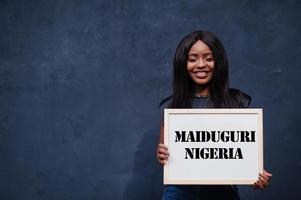 mulher africana segura quadro branco com inscrição maiduguri nigéria. cidade mais populosa do conceito de áfrica. foto