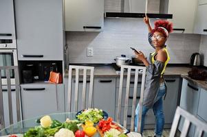 mulher afro-americana na cozinha de casa ligue o exaustor. foto