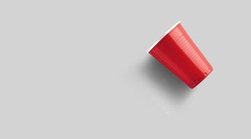 copo de plástico vermelho isolado em cinza. conceito de jogo de pong de cerveja foto
