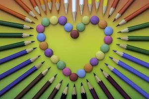 doces multicoloridos em forma de coração e giz de cera colorido foto