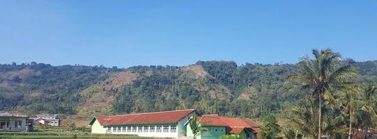 um edifício verde sob a colina. foto