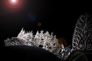 coroa de prata de diamante para concurso de beleza de concurso de miss, joias de tiara de cristal decoradas com pedras preciosas e fundo escuro abstrato em tecido de veludo preto, espaço de cópia de macro fotografia para logotipo de texto foto