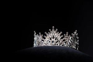 coroa de prata de diamante para concurso de beleza de concurso de miss, joias de tiara de cristal decoradas com pedras preciosas e fundo escuro abstrato em tecido de veludo preto, espaço de cópia de macro fotografia para logotipo de texto foto