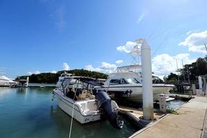 muitos iates de luxo flutuam no mar cristalino no clube marina bay, barco privado caro fica calmo no cais de ancoragem sob o céu azul de verão oceano verde foto