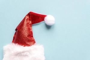 conceito mínimo de chapéu de papai noel. postura plana de ano novo de natal. fundo azul foto