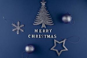 cartão festivo. feliz natal letras em papel azul com brinquedos azuis brilhantes. foto