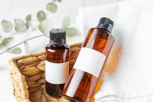 banheiro moderno e elegante com produtos para o rosto e corpo. garrafas, toalha em uma cesta de vime em uma mesa foto