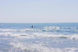 pessoas surfando no oean em um dia ensolarado foto