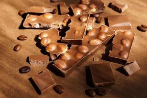 close-up de chocolate ao leite com avelãs em fundo marrom. sobremesa doce foto
