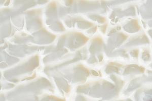 textura de creme. amostra de loção creme de beleza branca, fundo de esfregaço cosmético protetor solar. produto de mousse de cuidados com a pele cremoso close-up. foto