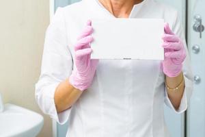 closeup foto das mãos do cosmetologista segurando uma caixa branca com enchimentos. cuidados de saúde, conceito médico e farmacêutico. maquete para o seu projeto