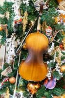 close-up da decoração da árvore de natal com enfeites, violino e guirlanda. cartão festivo para férias de inverno foto