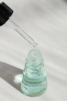 conta-gotas de óleo essencial, essência de aromaterapia ou líquido medicinal em fundo branco. foto