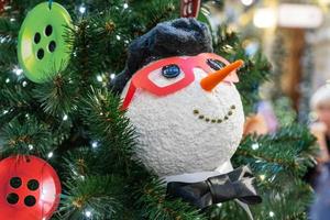 close-up da decoração da árvore de natal com botões e boneco de neve. cartão festivo para férias de inverno foto