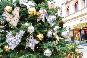 close-up de decoração de árvores de natal com brinquedos e guirlandas. decoração festiva da cidade durante as férias de inverno foto