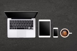laptop tablet smartphone e café no fundo da mesa de rock com espaço de texto e espaço de cópia foto