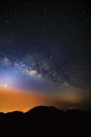 céu noturno estrelado com alta montanha e galáxia via láctea com estrelas e poeira espacial no universo foto