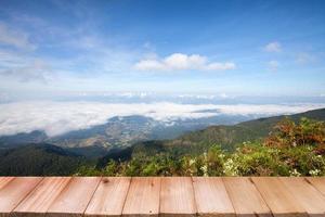 tampo de mesa de madeira na vista montanha e céu azul foto
